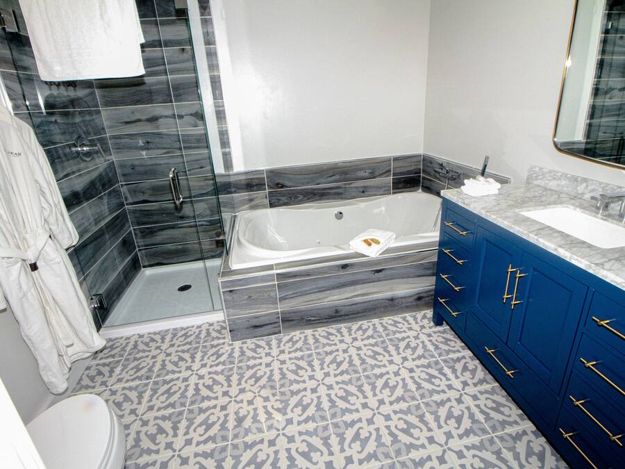 Un baño moderno con bañera, ducha y tocador con lavamanos.