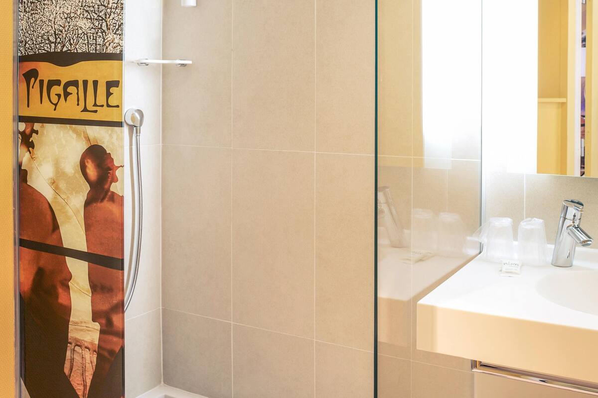 A bathroom with a shower, a sink, and a mirror.