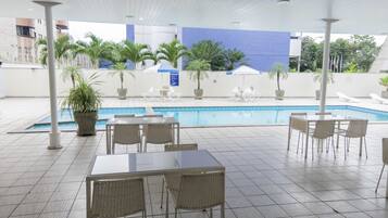 Relax by the pool surrounded by lush greenery and comfortable lounge seating.