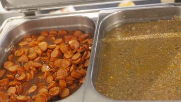 Deux récipients en métal, l’un contenant des tranches de saucisson et l’autre une sauce brune.