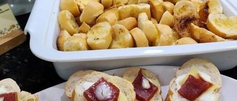 Ein Buffet mit verschiedenen Speisen, darunter Brot, Käse und Gebäck.