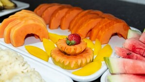 A fruit platter with sliced mangoes, cantaloupe, watermelon, and a strawberry garnish. - Arrey Express Hotel - Teresina (Teresina)