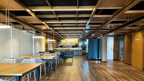 A modern hotel lobby with wooden flooring, a reception desk, seating area, and a bar. - Arrey Express Hotel - Teresina (Teresina)