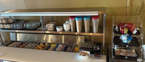 A breakfast bar with various food items and condiments.