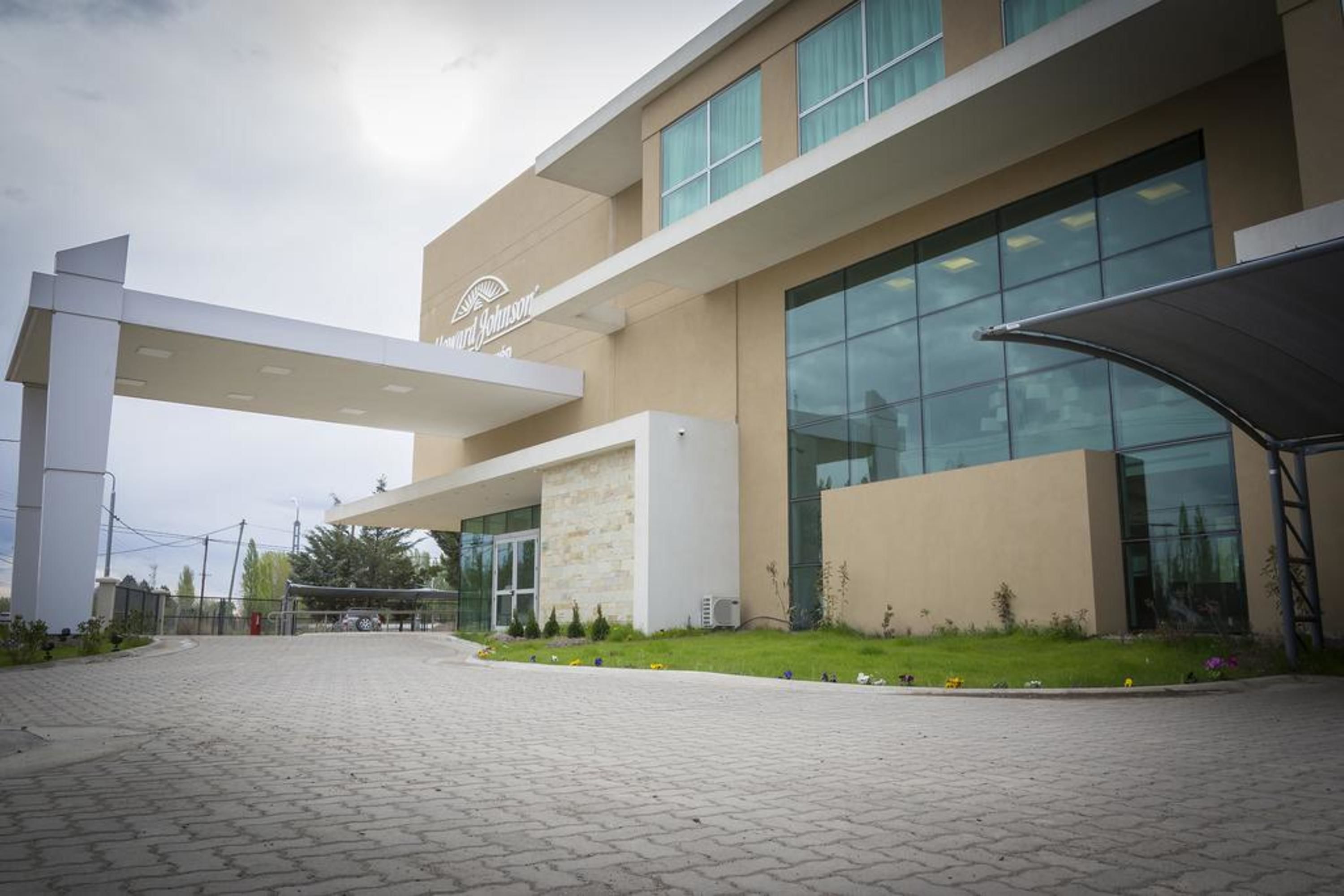 A modern building with a prominent entrance, large windows, and a well-maintained lawn.