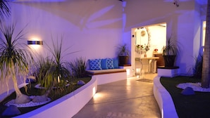 A modern interior with a curved pathway, potted plants, and a seating area with cushions. - Hotel HBlue Centro (La Paz)