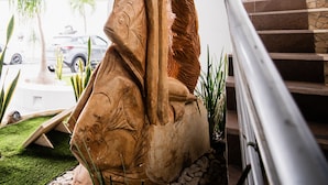 A sculpture of a fish and a bird in a garden setting with a staircase. - Hotel HBlue Centro (La Paz)