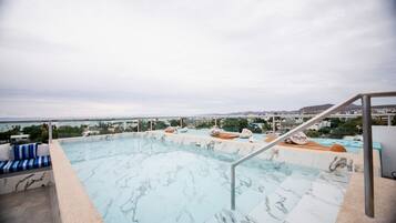 Una piscina infinita en la azotea con vistas a la ciudad y a las montañas.