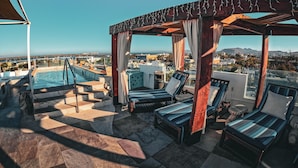 A rooftop pool area with lounge chairs and a pergola. - Hotel HBlue Centro (La Paz)