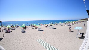 A beach with rows of white lounge chairs and umbrellas. - Hotel Villaggio Club ALTALIA (Brancaleone)