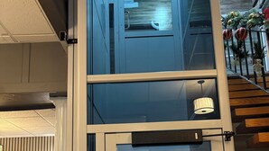 A hotel entrance with a glass door, a sign about construction work, and a Santa Claus decoration. - Hotel Port Aux Basques (Channel-Port aux Basques)