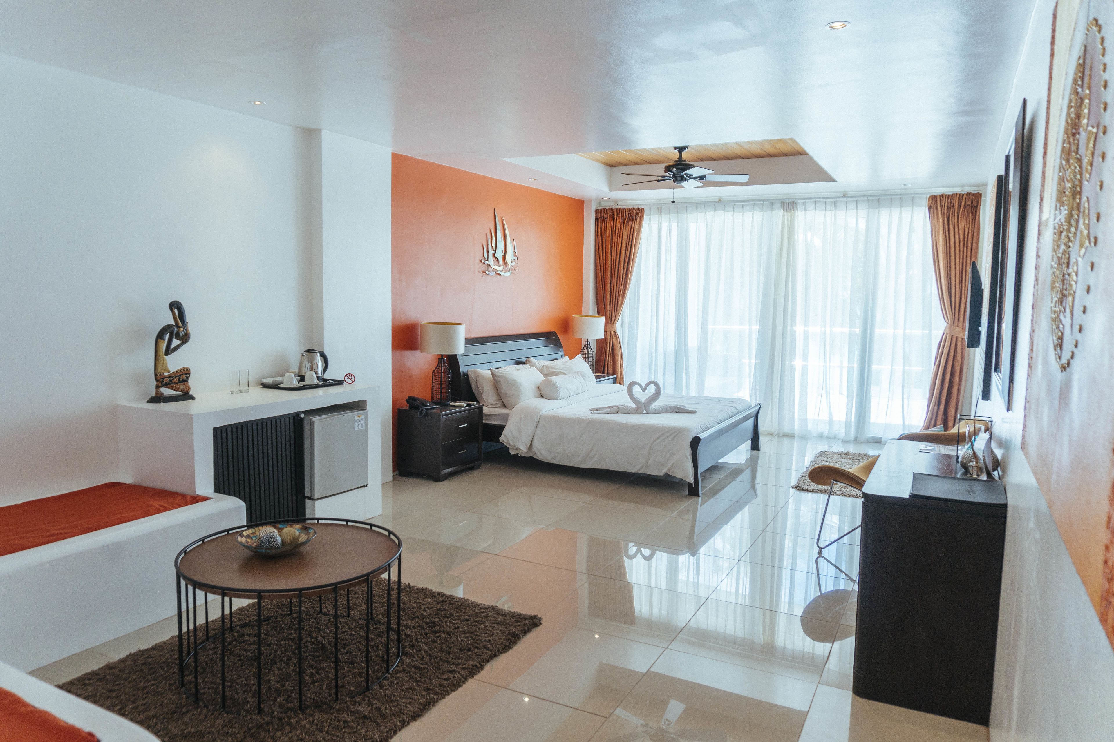 A modern hotel room with a bed, bedside table, and a seating area with a small table and chairs.