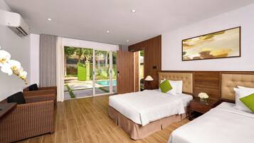 Una habitación de hotel con una cama grande, un sofá, una mesita y vistas a una piscina.