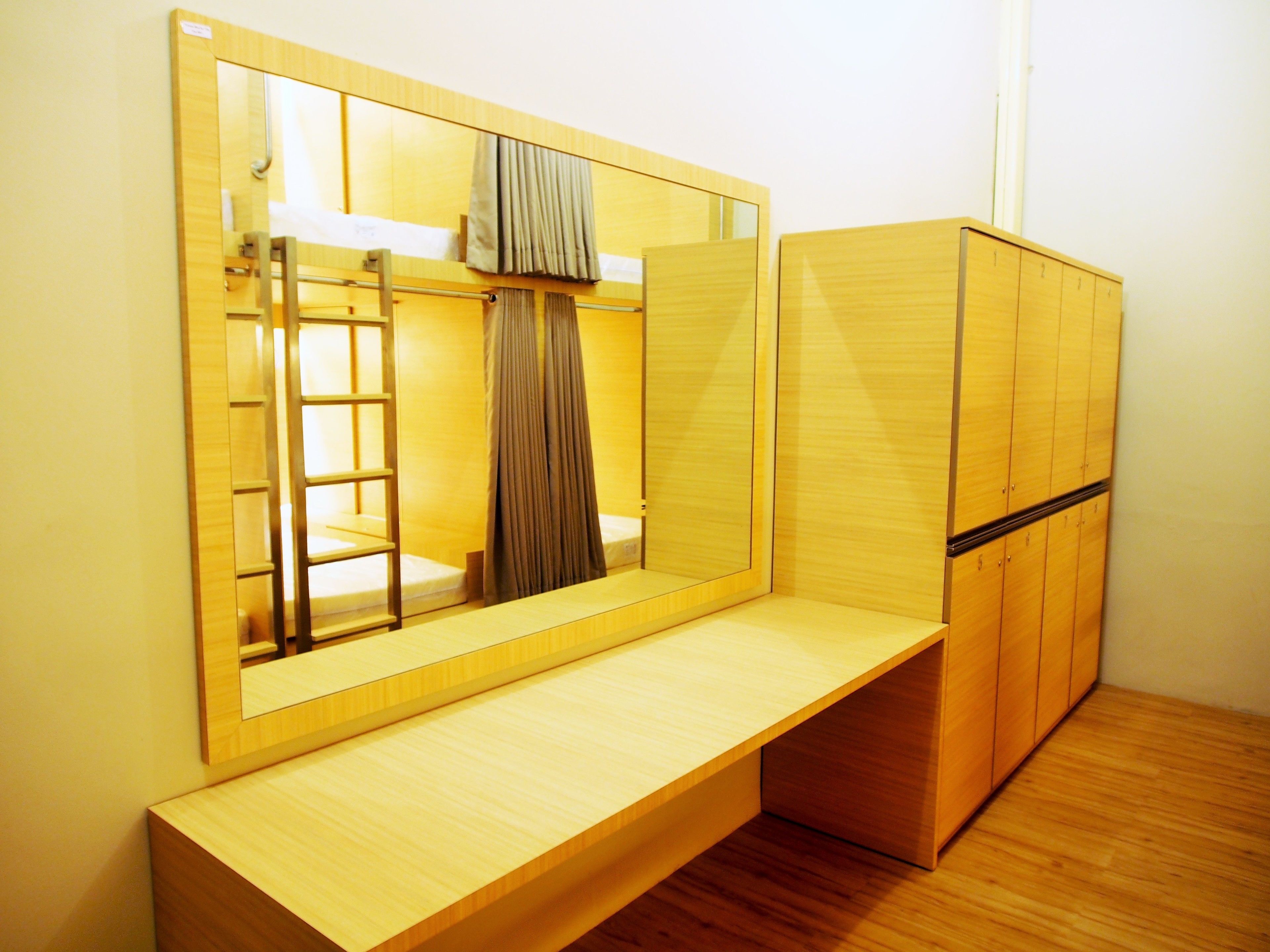Una habitación con un espejo grande, muebles de madera y un banco.