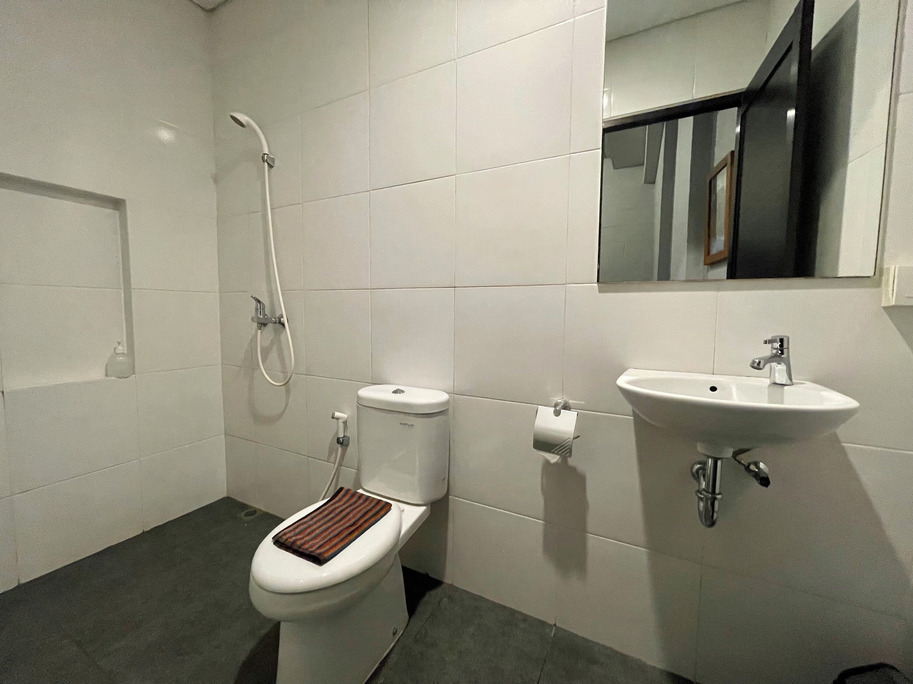 Un baño con inodoro, ducha y lavamanos.