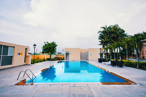 Outdoor pool, open 7:00 AM to 7:00 PM, pool umbrellas