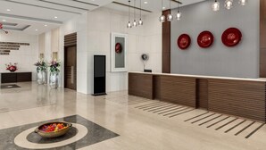 A modern reception area with a reception desk, hanging pendant lights, and decorative plates on the wall.
