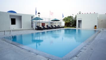 Una piscina al aire libre, sombrillas