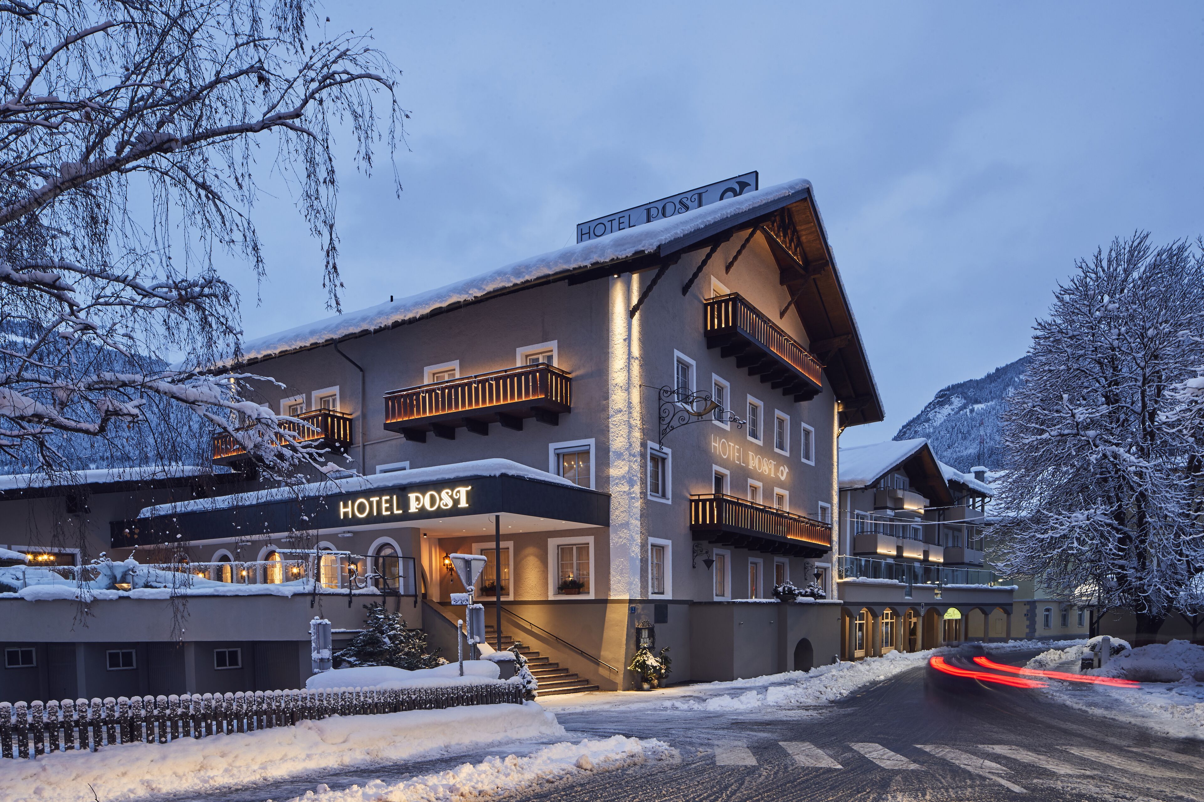 A hotel with a sign reading "HOTEL POST" and a staircase leading to the entrance.