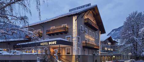 A hotel with a sign reading "HOTEL POST" and a staircase leading to the entrance.