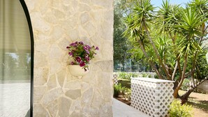 A stone wall with a flower pot and a lattice fence in a garden area. - La Maison One B&B (Carovigno)