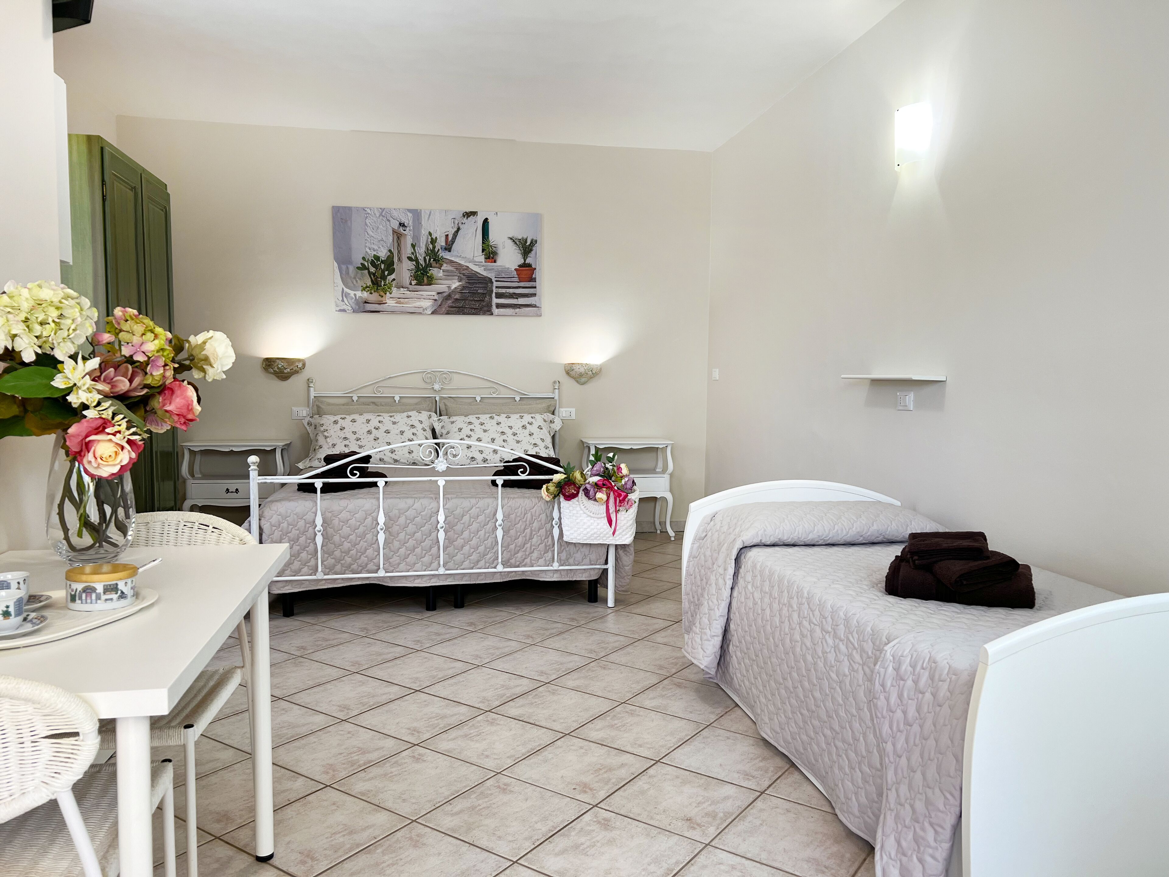 Un dormitorio con cama, mesita de noche y un cuadro en la pared.