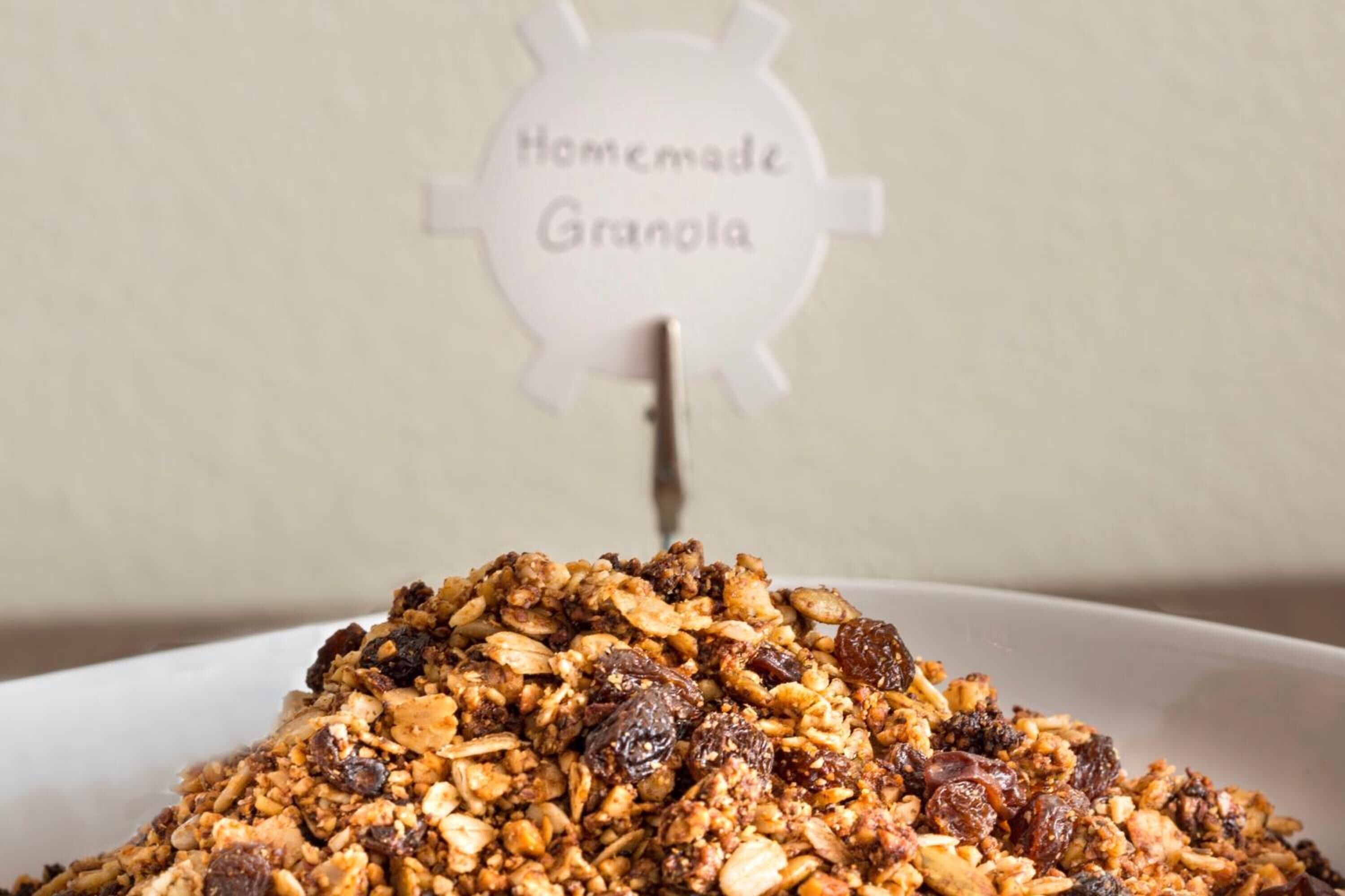 A bowl of homemade granola with raisins.