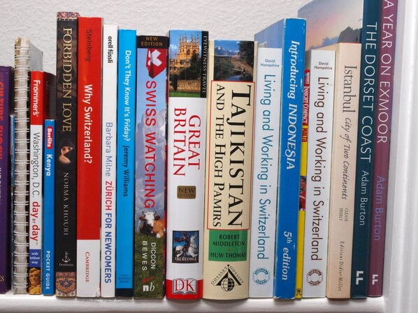 Una estantería con varios libros de viajes.