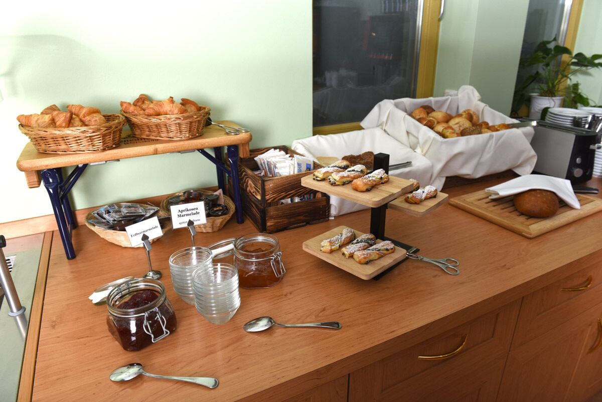 Un buffet de petit-déjeuner proposant un assortiment de viennoiseries, de pains et de condiments.