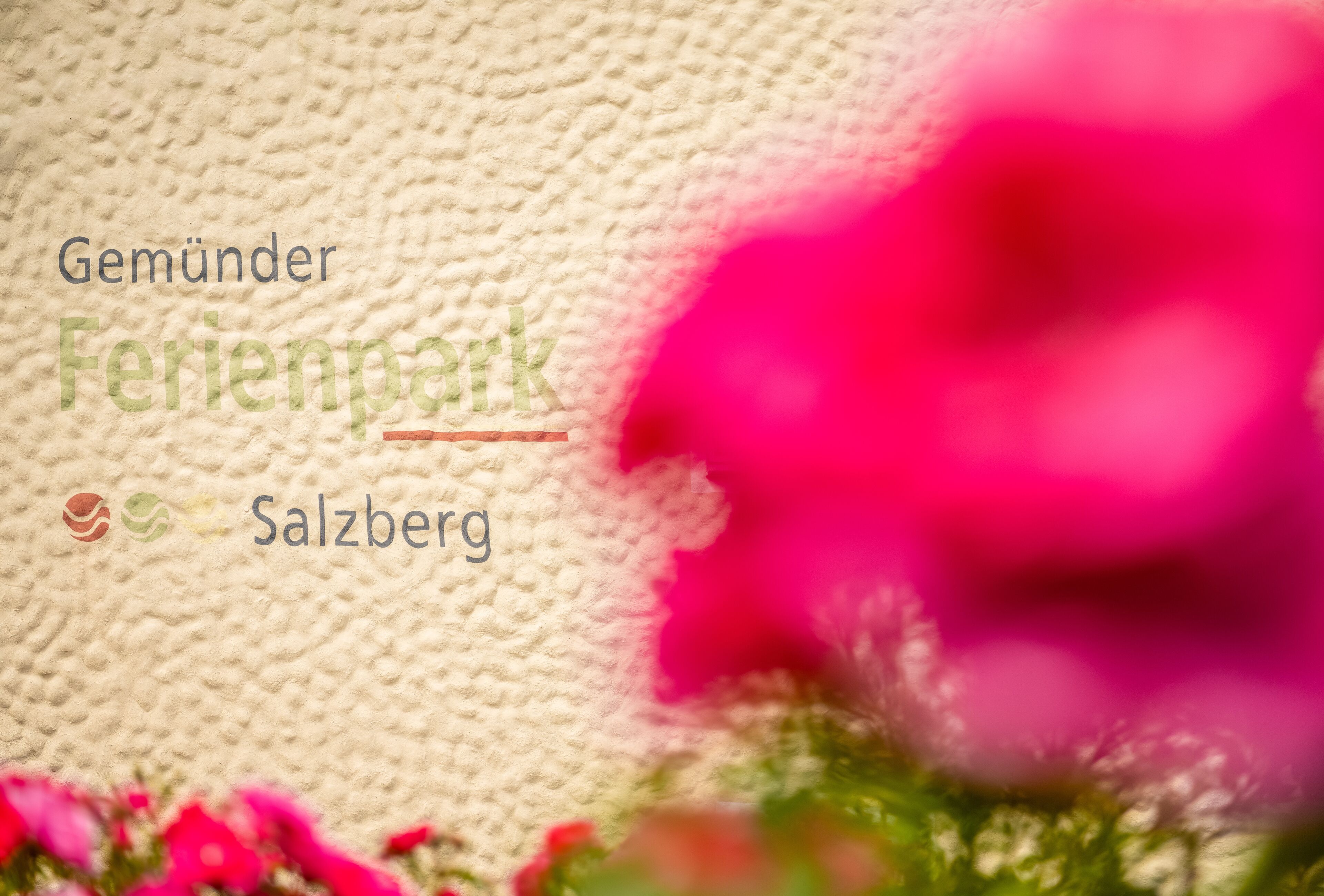 A textured fabric background with the text "Gemünder Ferienpark Salzburg" and a logo.