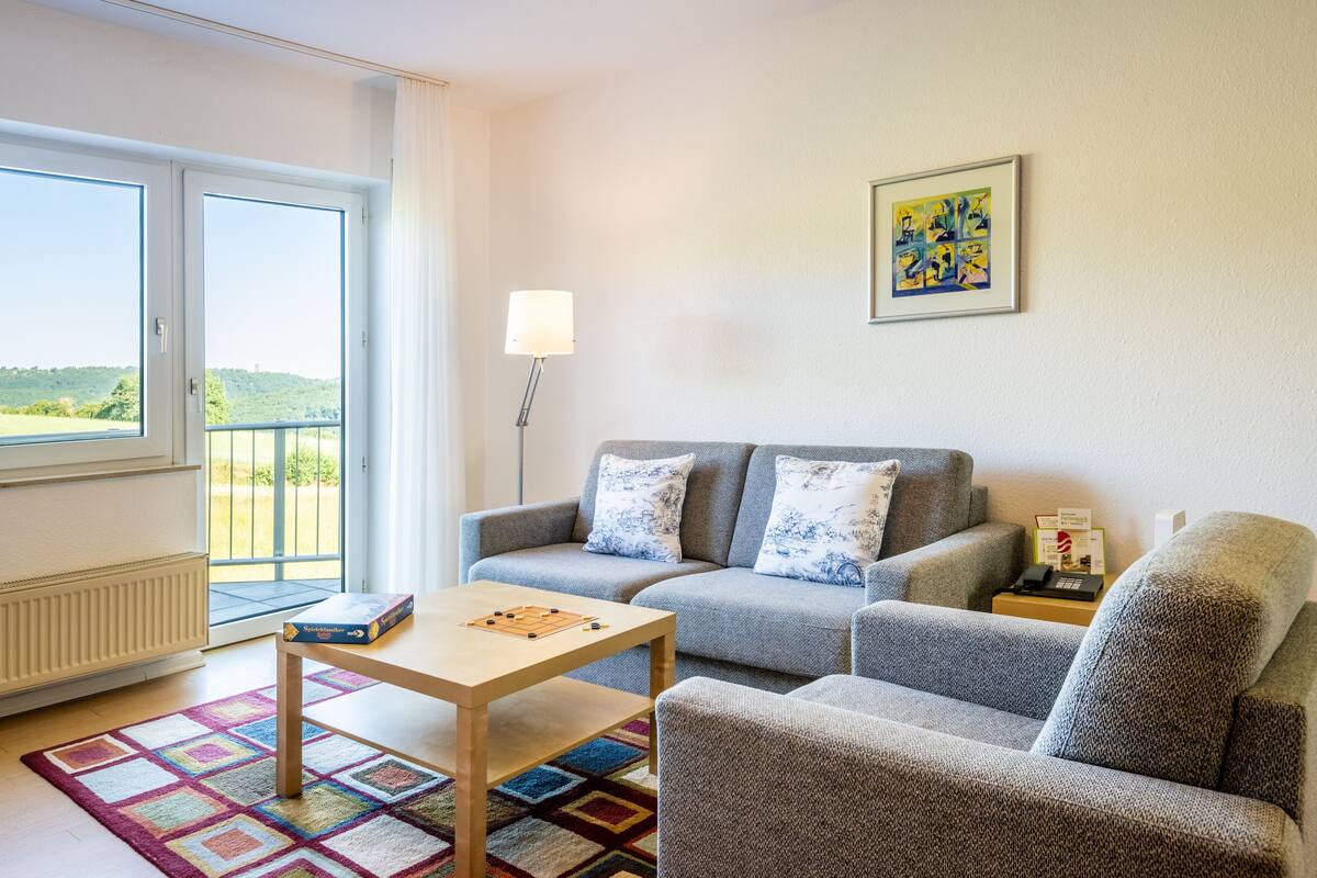 Un salon avec un canapé, une table basse, une lampe et un jeu d’échecs.