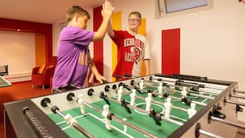 Enjoy a game of foosball in this lively room, featuring a table with multiple rods and figures.