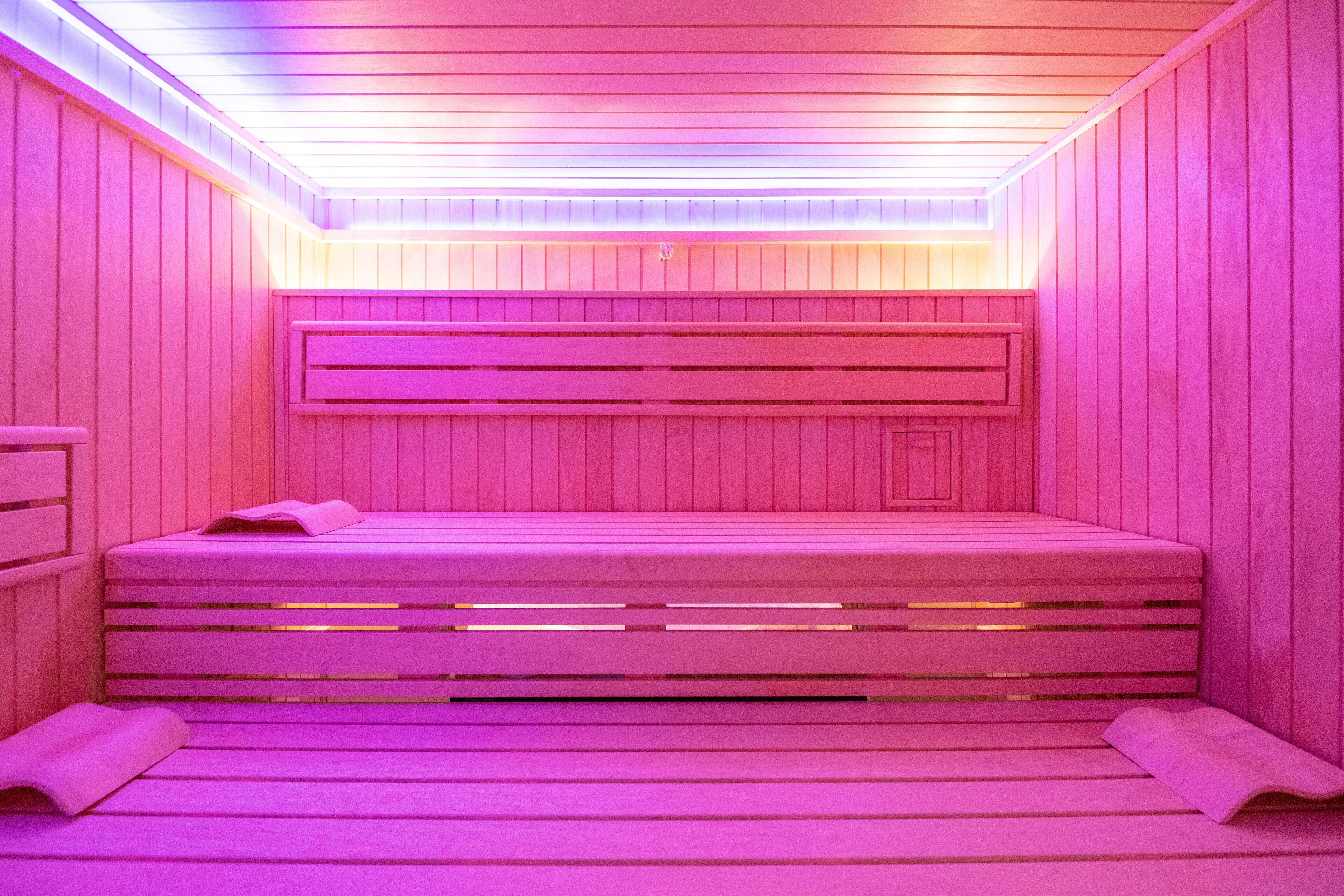 A sauna with wooden benches and a sloped ceiling.