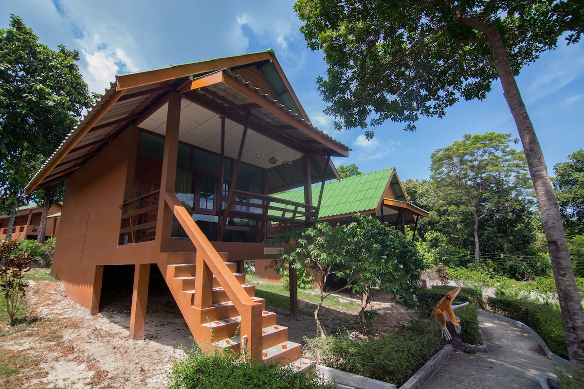 A modern building with a unique architectural design, featuring a large balcony and a staircase leading to the upper floor.