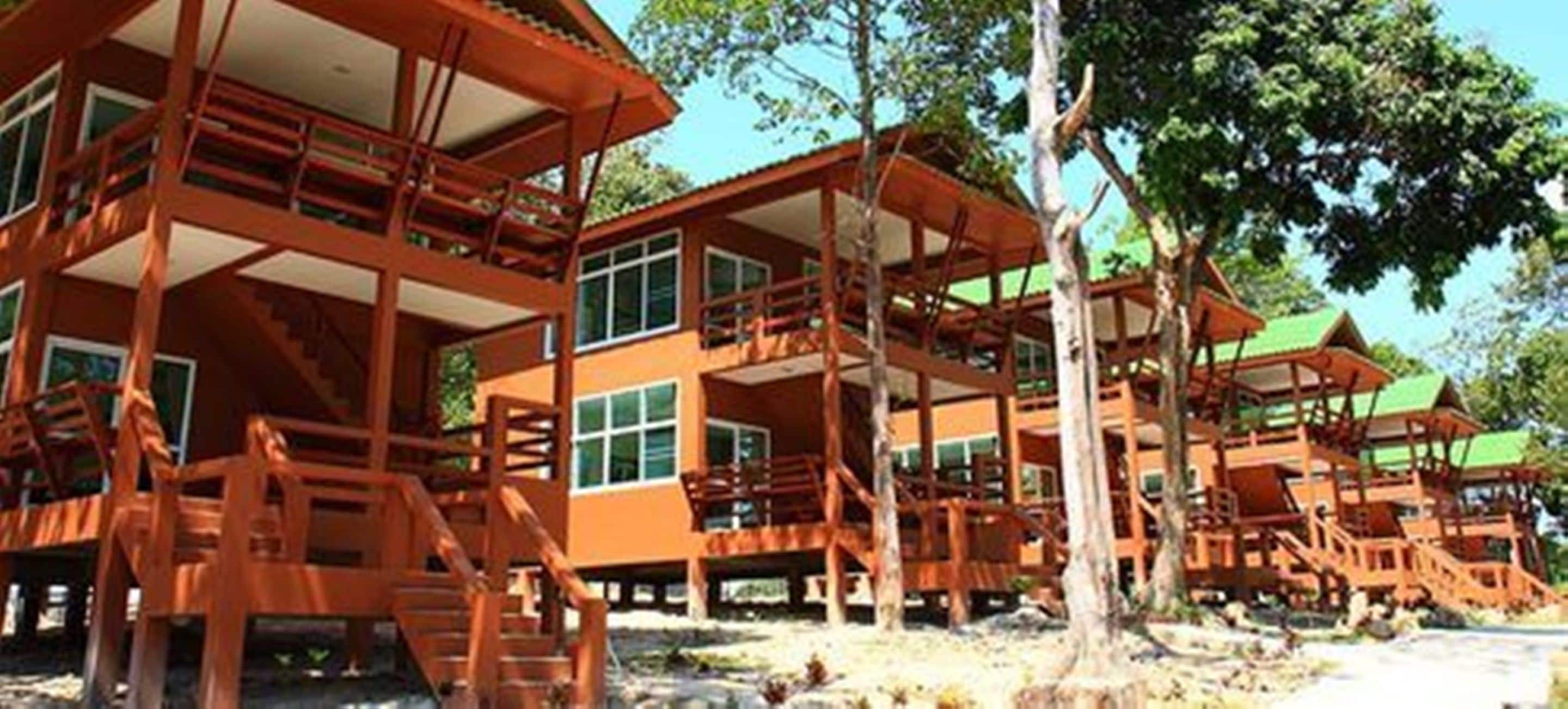 A multi-story wooden structure with balconies and large windows, likely a resort or hotel.