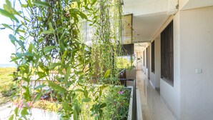 Un balcón con vistas a un jardín y un edificio al fondo.