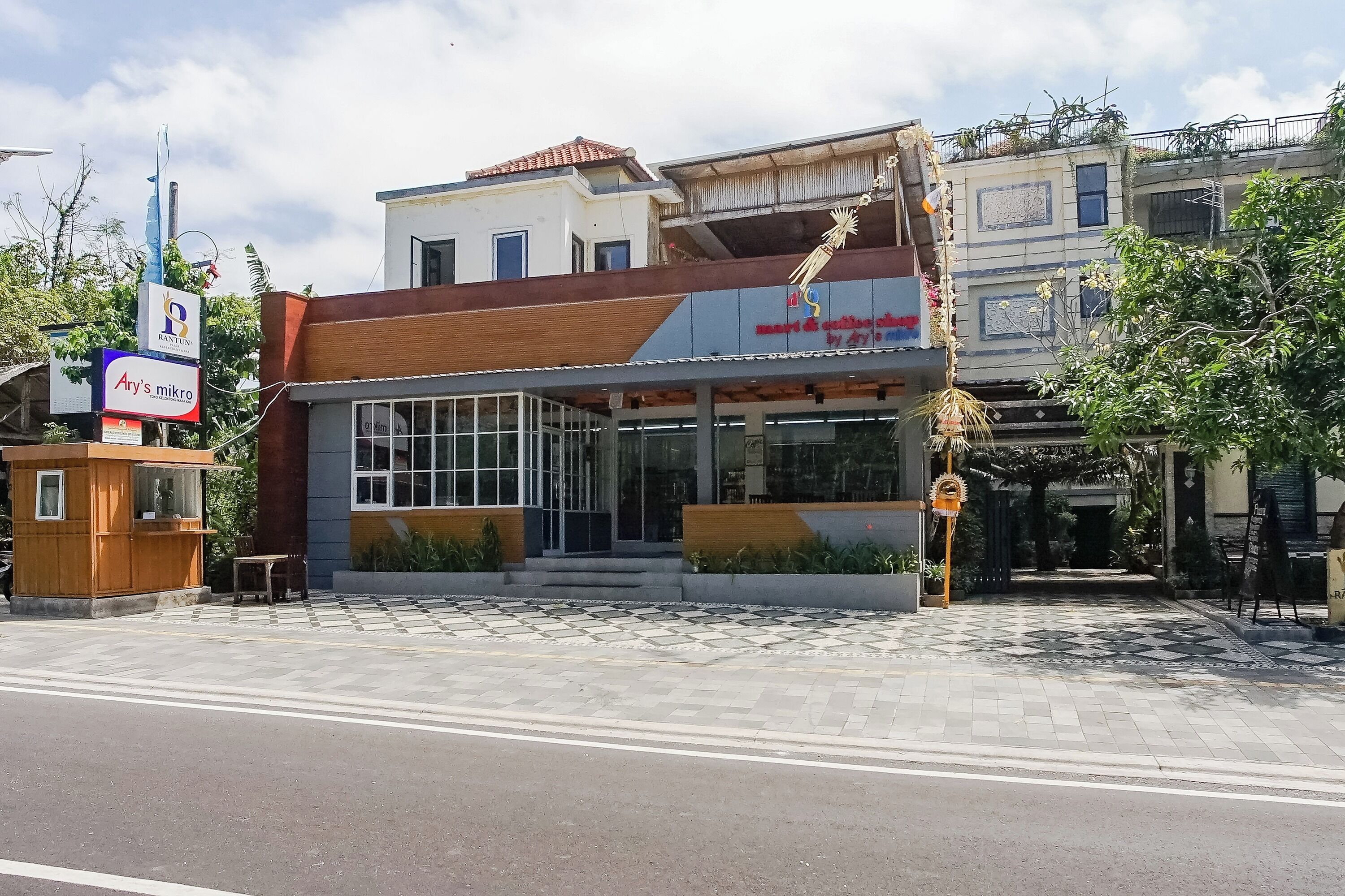 A building with a modern facade, large windows, and a tiled entrance area.