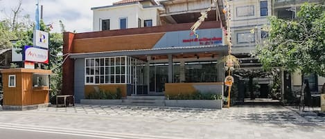 A building with a modern facade, large windows, and a tiled entrance area.