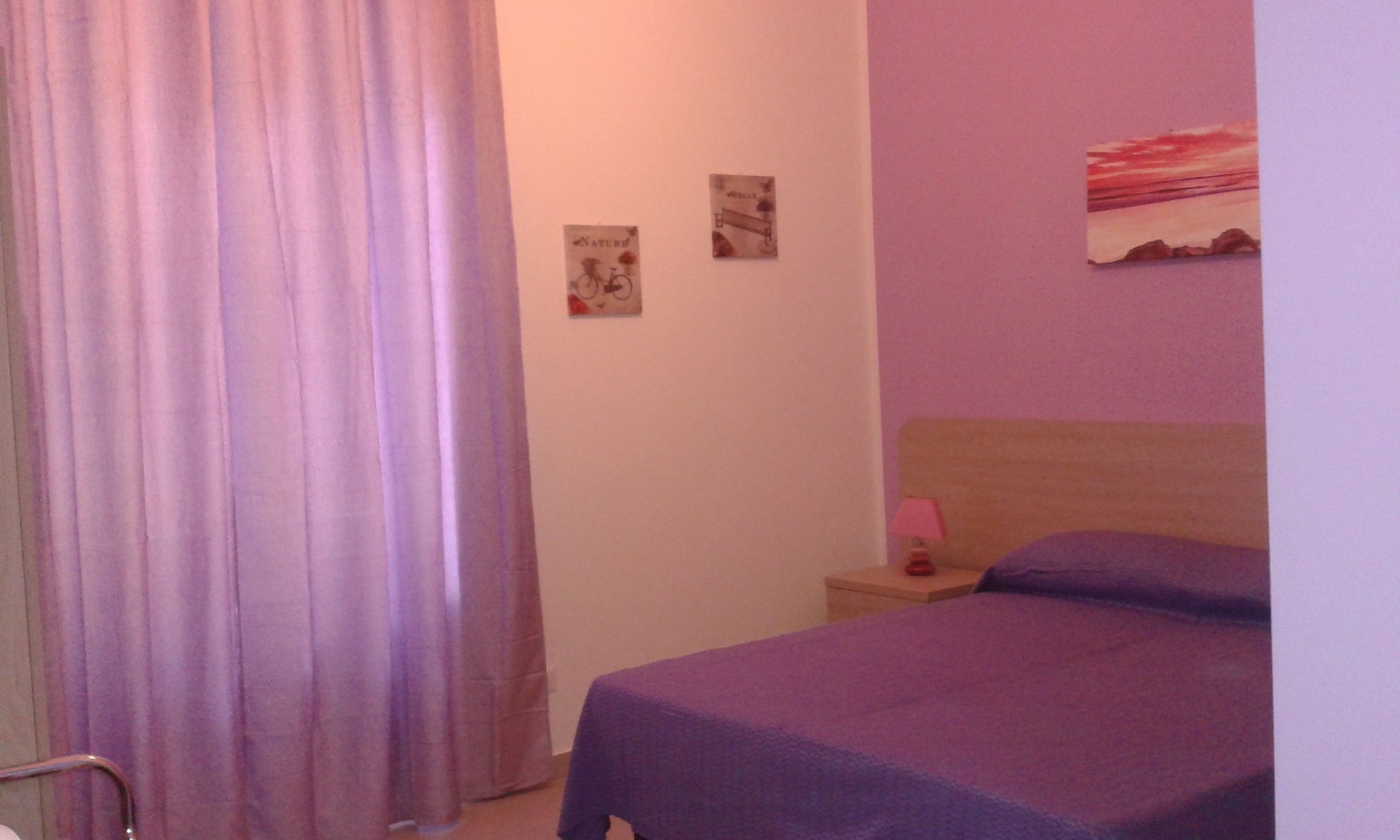 Une chambre à coucher comprenant un lit, une table de chevet, une lampe et deux éléments de décoration murale.