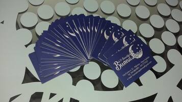 A blue fan with a moon and stars design, placed on a table with a white circular pattern.