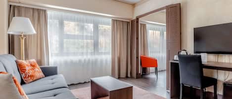 Una sala moderna con sofá, mesa de centro y televisión.
