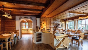 Un intérieur en bois comprenant une cuisine et un coin repas, avec des meubles en bois et une grande fenêtre.