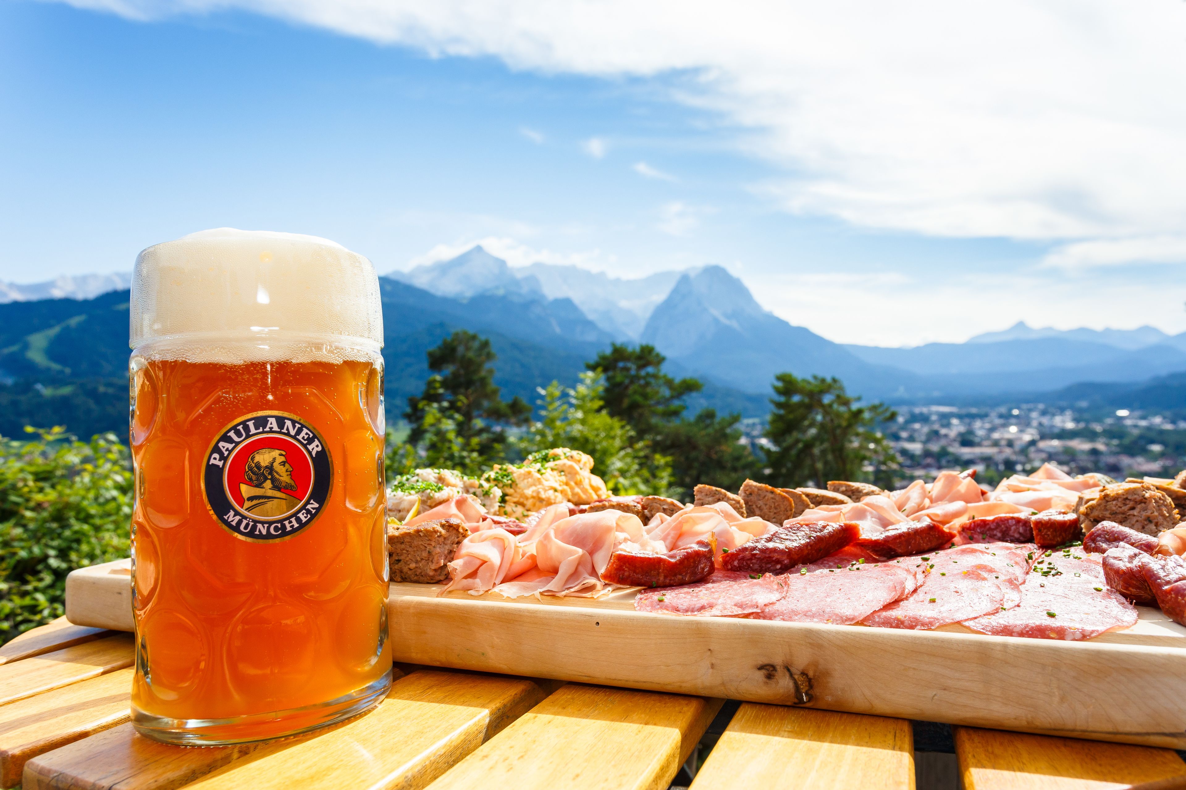 A beer mug with a mountain view in the background.