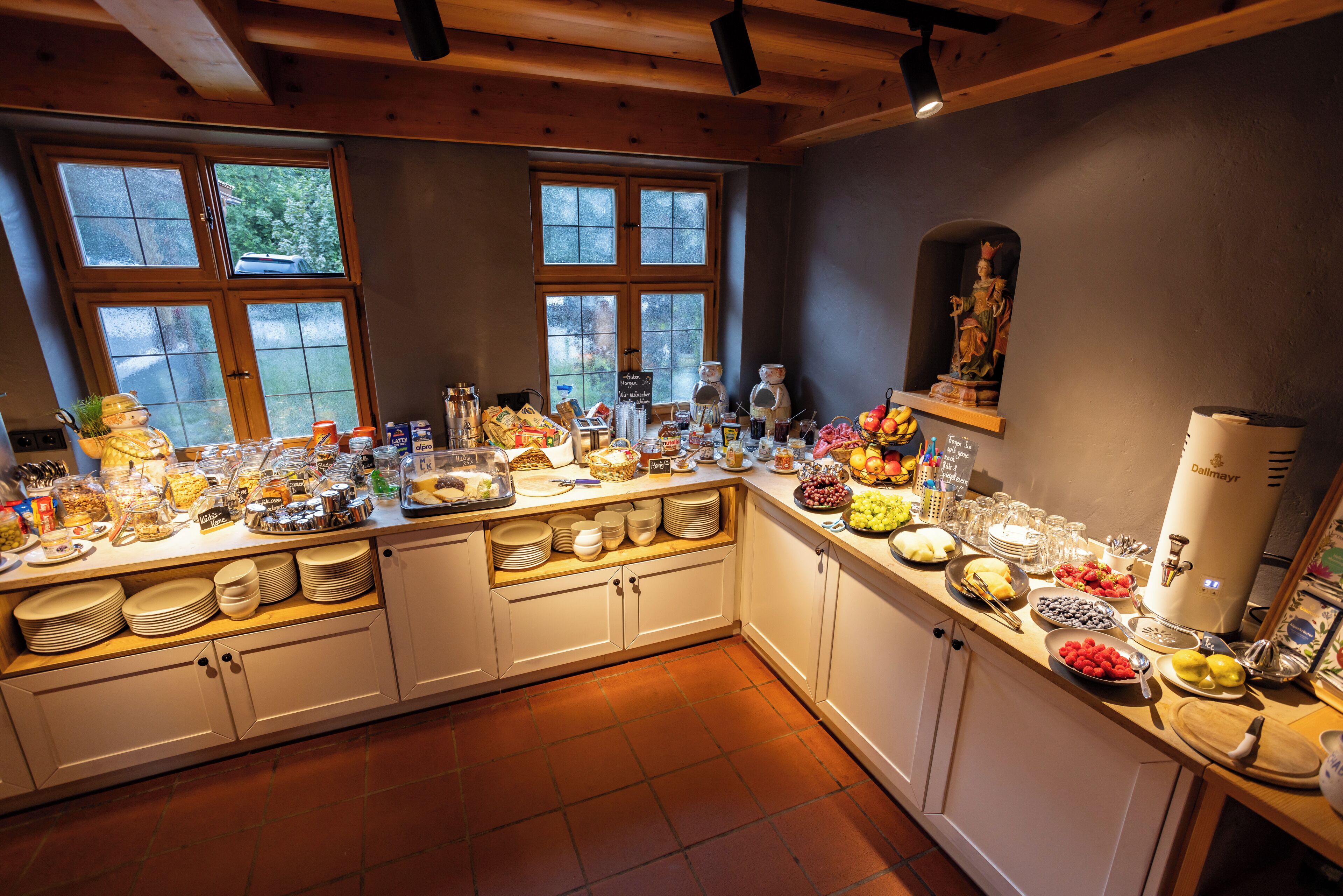 A kitchen with a breakfast buffet setup, including various food items and utensils.
