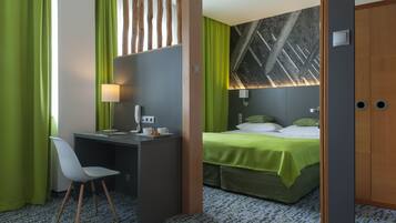 Une chambre d’hôtel équipée d’un bureau, d’une chaise, d’un lit et ornée d’une grande fresque murale.