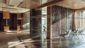 A modern interior with a glass partition, wooden ceiling, and contemporary chairs. - Hotel Villa Park Med & Spa (Ciechocinek)