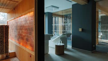 Une salle de spa moderne avec un mur en briques, un plafond en bois et une cloison en verre.