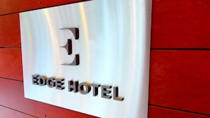Un letrero para el HOTEL EDGE con acabado metálico y un gran logotipo 'E'.