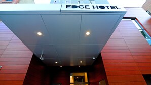 Entrada del HOTEL EDGE, con fachada roja y diseño moderno.