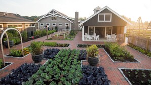 A residential area with a garden, a patio with outdoor furniture, and a house with a chimney. - The Inn at Chesapeake Bay Beach Club (Stevensville)